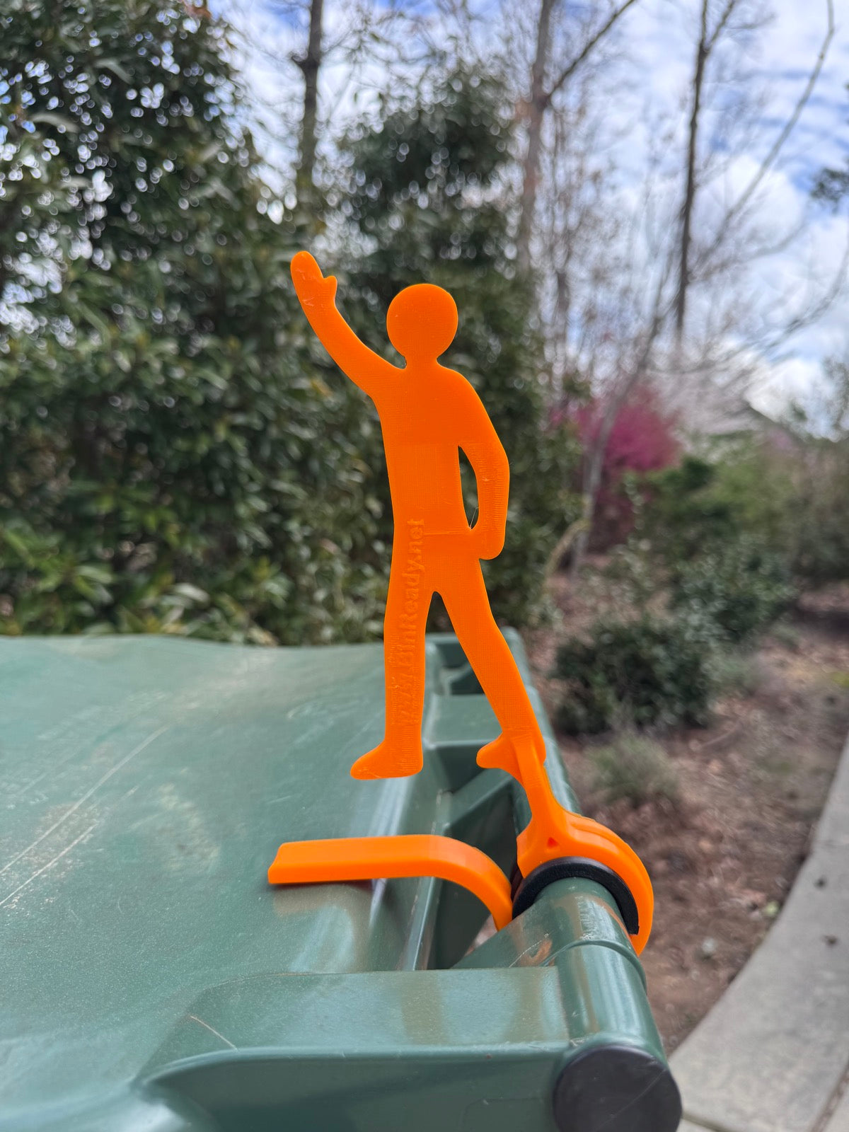 Ready Eddie standing up with arm raised on a green bin — bin still needs pickup